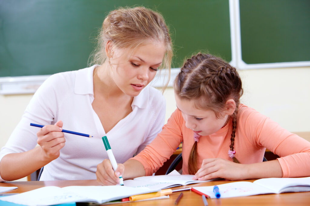 coach scolaire aidant une élève